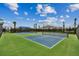 Tennis court with blue and green surface, nets, and fencing surrounded by palm trees at 7440 Cabin Ln, Sarasota, FL 34240