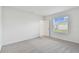 A bright bedroom featuring neutral carpeting and a view of the neighborhood through a single window at 9809 Last Light Gln, Parrish, FL 34219