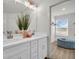 Bathroom with double vanity sink and an ottoman near the walk-in closet at 13725 Emerald Fields Dr, Hudson, FL 34667