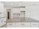 Close-up of a kitchen island that features granite countertops and white cabinets at 18063 Cherished Loop, Bradenton, FL 34211