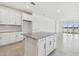 Bright kitchen features granite countertops, island and a view of the lake through large sliding glass doors at 18063 Cherished Loop, Bradenton, FL 34211