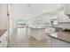 Open kitchen with stainless appliances, granite countertops, island, and view to a lake through sliding glass doors at 18063 Cherished Loop, Bradenton, FL 34211