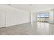 Bright living room with tiled floors, sliding glass doors with views to the lake, and white walls at 18063 Cherished Loop, Bradenton, FL 34211