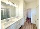 Modern bathroom featuring double sinks, a large mirror, and a glass-enclosed shower with neutral tones at 7950 Chandler Lake Ct, Hudson, FL 34667