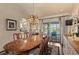 Sunlit dining room boasting a wooden table, pendant lighting, and sliding door access to the outdoor space at 1336 Roosevelt Dr, Venice, FL 34293