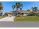 Well-maintained single-story home with a two-car garage, long driveway, and a green lawn at 1336 Roosevelt Dr, Venice, FL 34293