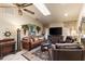 Comfortable living room with a ceiling fan, skylight, and a large TV for relaxation and entertainment at 1336 Roosevelt Dr, Venice, FL 34293