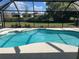 A screened-in pool offers a private oasis with clear blue water and a view of the lush greenery beyond at 1336 Roosevelt Dr, Venice, FL 34293
