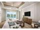 Bright living room with large windows overlooking a pool, a comfortable sofa, and modern decor at 1741 Lugano Cir, Nokomis, FL 34275