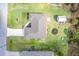 An aerial view of the home, surrounded by green lawn and mature trees, showing the roof layout at 18149 Dillon Ave, Port Charlotte, FL 33954
