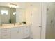 Well-lit bathroom with double sinks, marble countertop, and a glass-enclosed shower at 229 Vistera Blvd, North Venice, FL 34275