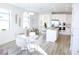 A bright dining area and kitchen featuring white cabinets, stainless steel appliances, and modern light fixtures at 229 Vistera Blvd, North Venice, FL 34275