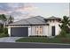 Charming single-story home featuring a two-car garage and tropical landscaping at 229 Vistera Blvd, North Venice, FL 34275