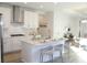 Modern white kitchen with stainless steel appliances, a central island with seating, and an open layout at 229 Vistera Blvd, North Venice, FL 34275