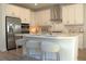 Bright, white kitchen featuring stainless steel appliances, subway tile backsplash, and an island with counter seating at 229 Vistera Blvd, North Venice, FL 34275