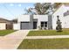 Modern home featuring a gray brick facade, gray garage door, tidy lawn and walkway at 3508 E 11Th Ave, Tampa, FL 33605