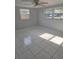 This bedroom offers neutral walls, white tile flooring, two windows, and a ceiling fan at 3542 Trask Dr, Holiday, FL 34691