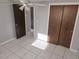 Bedroom featuring tile floors, neutral walls, ceiling fan, closet and attached bathroom at 3542 Trask Dr, Holiday, FL 34691