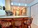 Eat-in kitchen with light wood cabinets, bar seating, and modern lighting fixtures at 468 Ceil Dr, Nokomis, FL 34275