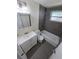 Updated bathroom with gray tile, vanity, and tub with shower, offering a clean design at 4823 Blossom Dr, Holiday, FL 34690
