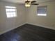Cozy bedroom with two windows, wood-look floors, and a ceiling fan for a relaxing space at 4823 Blossom Dr, Holiday, FL 34690