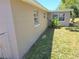 Tan exterior of home with green grass growing along side of house at 4823 Blossom Dr, Holiday, FL 34690