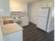 Efficient kitchen featuring white appliances, cabinets, and wood-look flooring at 4823 Blossom Dr, Holiday, FL 34690
