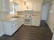 Functional kitchen with white cabinets, appliances, and updated wood-look flooring at 4823 Blossom Dr, Holiday, FL 34690