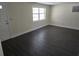 Spacious living room with wood-look floors, and plenty of natural light from the window at 4823 Blossom Dr, Holiday, FL 34690