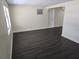 Bright living room with dark wood-look floors, neutral walls, and ample natural light at 4823 Blossom Dr, Holiday, FL 34690
