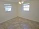 This simple bedroom features tile floors, two windows, and neutral paint at 5014 Galaxy Dr, New Port Richey, FL 34652