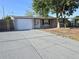 Exterior view of a single-story home with an extended driveway and attached garage in a suburban neighborhood at 5014 Galaxy Dr, New Port Richey, FL 34652