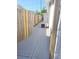 Narrow side yard features a concrete path, wooden fence and outdoor AC unit at 5014 Galaxy Dr, New Port Richey, FL 34652