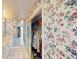 Walk-in closet with floral wallpaper, mirrored doors, and functional storage solutions at 671 Roanoke Rd, Venice, FL 34293