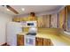 Cozy kitchen featuring wood cabinets, a white refrigerator, and essential appliances for home cooking at 671 Roanoke Rd, Venice, FL 34293