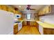 Bright kitchen featuring wood cabinets, white appliances, and wood floors at 671 Roanoke Rd, Venice, FL 34293