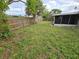Backyard features a wood fence, well-maintained lawn, mature trees, and a screened-in porch at 7352 Sequoia Dr, New Port Richey, FL 34653