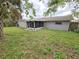 Expansive backyard featuring a screened-in porch, a wood fence, and a lush lawn at 7352 Sequoia Dr, New Port Richey, FL 34653