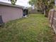 Spacious backyard featuring a wood fence, well-maintained lawn, and partial views of the house at 7352 Sequoia Dr, New Port Richey, FL 34653