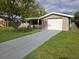 Single-story home with a well-manicured lawn, featuring a one-car garage and a gray driveway at 7352 Sequoia Dr, New Port Richey, FL 34653