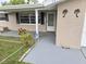 View of the home's entrance, featuring a covered porch, a decorative palm tree emblem, and brick accents at 7352 Sequoia Dr, New Port Richey, FL 34653