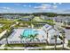 Aerial view of community pool surrounded by palm trees, lounge chairs, playground, and tennis courts at 7432 Cabin Ln, Sarasota, FL 34240