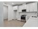 Modern kitchen featuring white cabinets, stainless steel appliances, and a breakfast bar at 17982 Cherished Loop, Bradenton, FL 34211