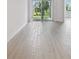 Spacious living room with light wood-look floors and access to an outdoor patio at 17982 Cherished Loop, Bradenton, FL 34211