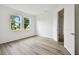 Sunlit bedroom with wood-look tile flooring and a view of the outdoors through two large windows at 17986 Cherished Loop, Bradenton, FL 34211