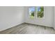 Bedroom featuring wood-look tile flooring and a view of the outdoors through two windows at 17986 Cherished Loop, Bradenton, FL 34211
