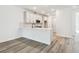 Bright kitchen featuring white cabinets, modern appliances, and wood-style flooring, adjacent to the living area at 17986 Cherished Loop, Bradenton, FL 34211