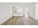 Open-concept living space showcasing wood-style floors and a view of the kitchen and hallway at 17986 Cherished Loop, Bradenton, FL 34211