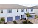 A lovely aerial view of a townhome showcases blue garage doors, shutters, brick driveway and manicured landscaping at 5425 Tripoli Dr, Palmetto, FL 34221
