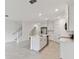 Modern, open-concept kitchen with white cabinetry, stainless appliances, island and tile flooring at 5425 Tripoli Dr, Palmetto, FL 34221